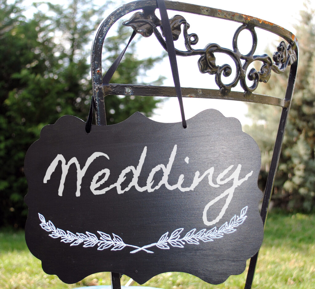 Chalkboard on outdoor chair with Wedding written on it