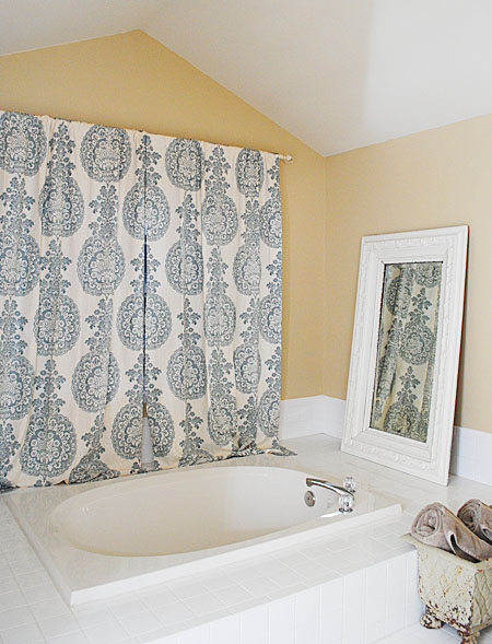 blue curtains by bathtub with old mirror