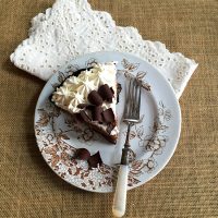 A piece of Marie Callender's Chocolate pie on a plate with Eyelet napkin and fork