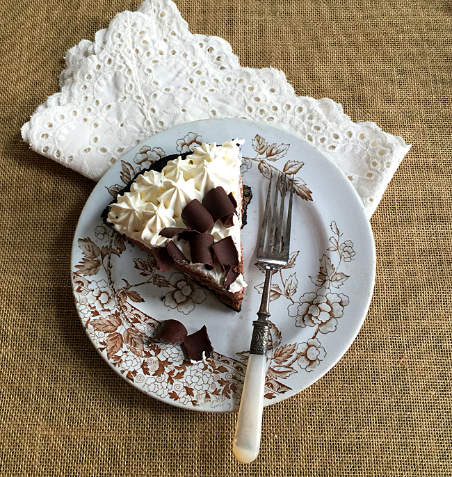A piece of Marie Callender\'s Chocolate pie on a plate with Eyelet napkin and fork