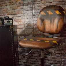 grungy painted desk chair with brick wall and camera