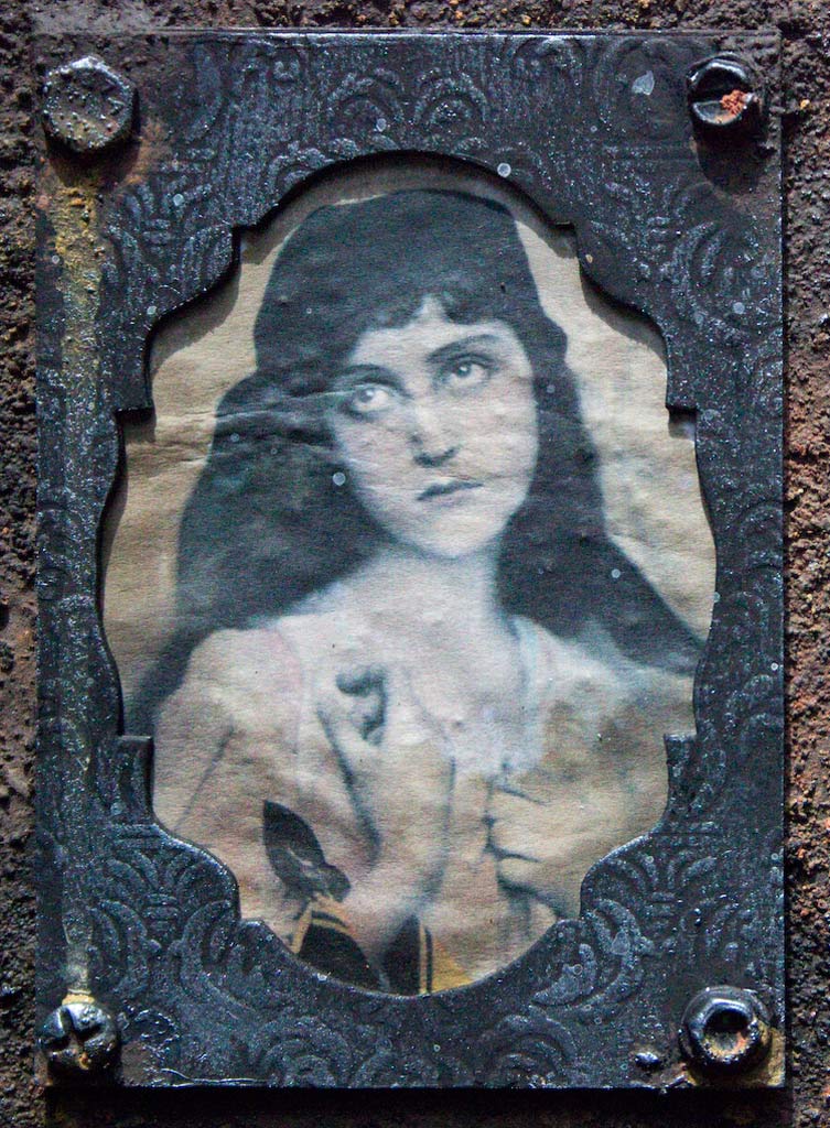 Rust paste board with antique photos of people close up