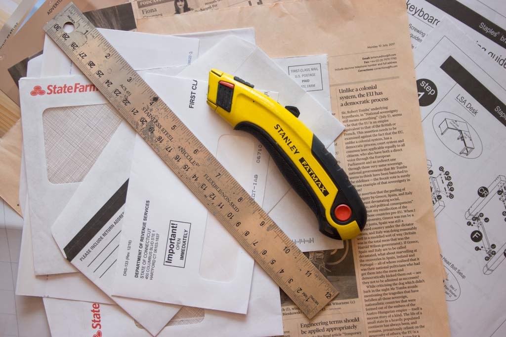 Junk mail pile with knife and ruler