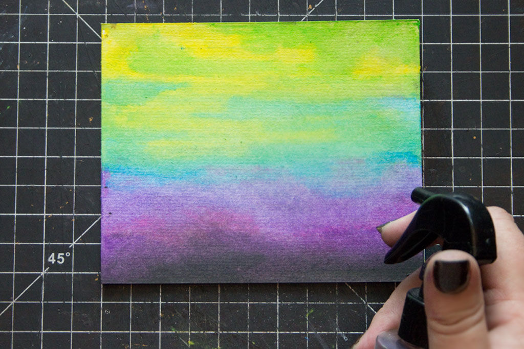 spraying water on colored paper