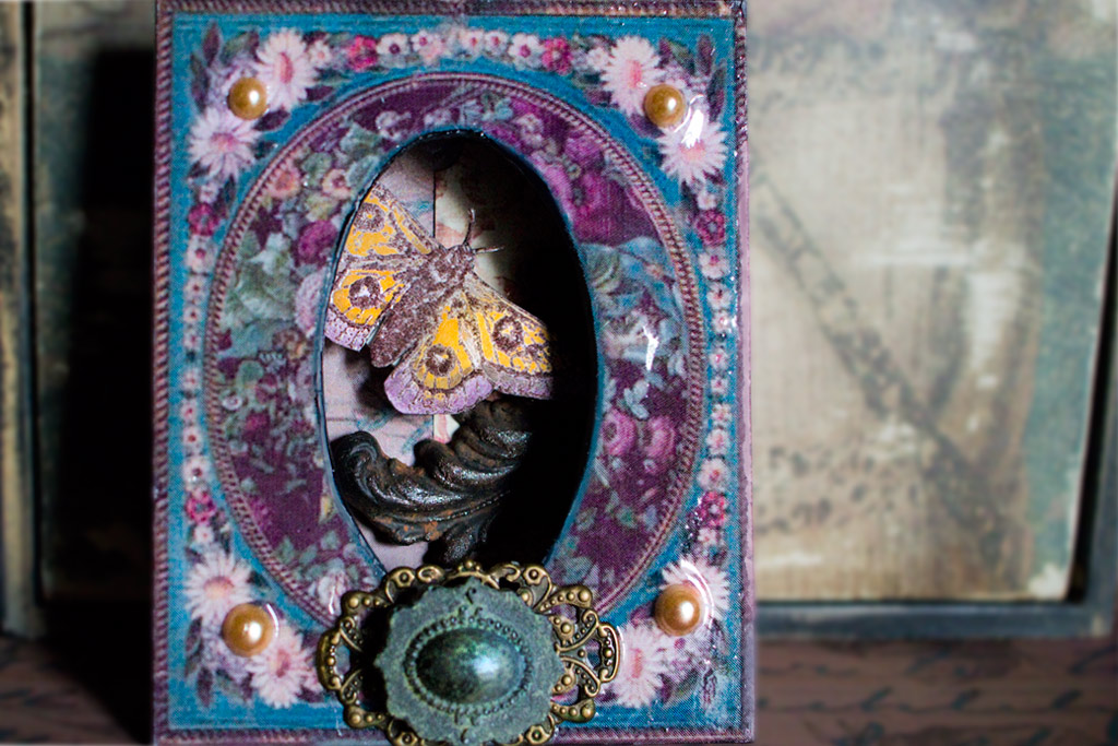 box with butterfly inside and jewels on frame