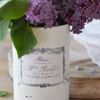 white can with french label and lilacs