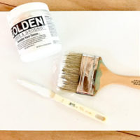 Gesso with paintbrush and paper craft