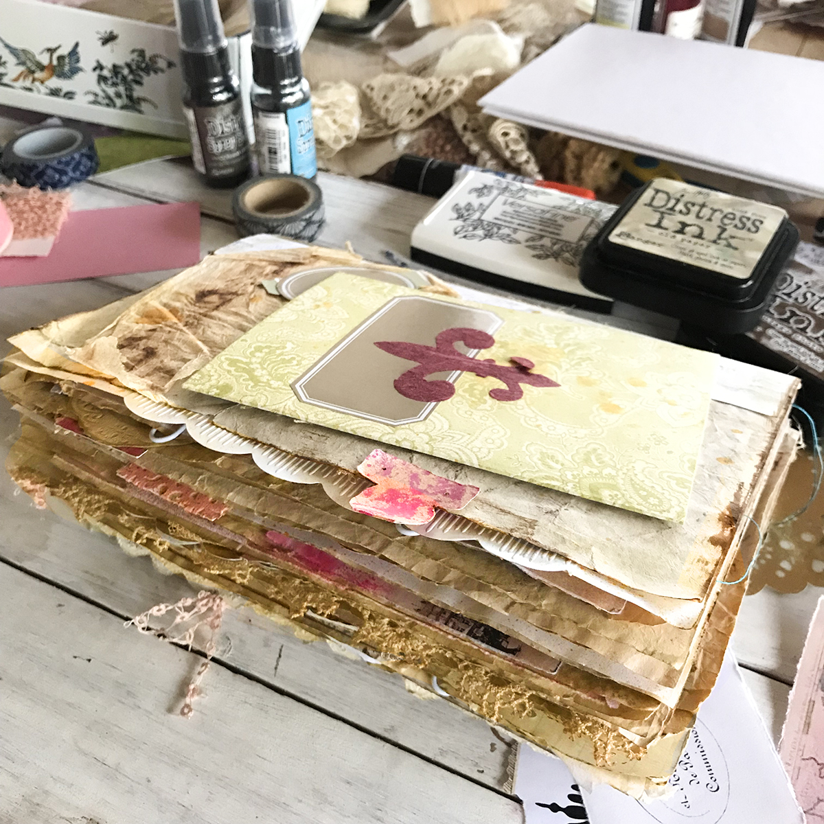 A table with papers and art supplies all over it and junk journal