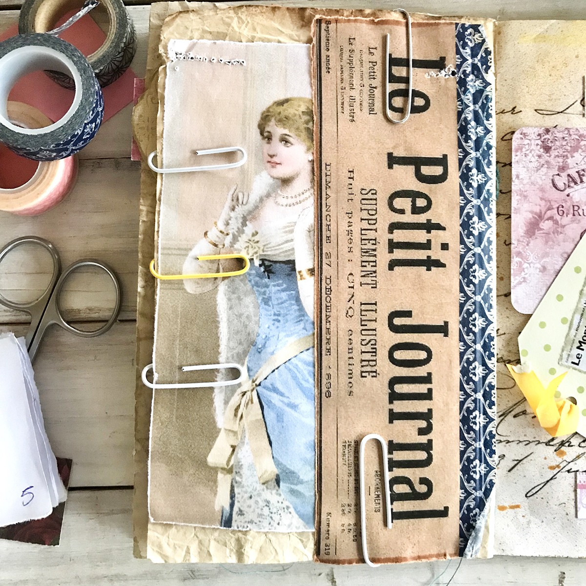 French glue book page with lady and paper clips