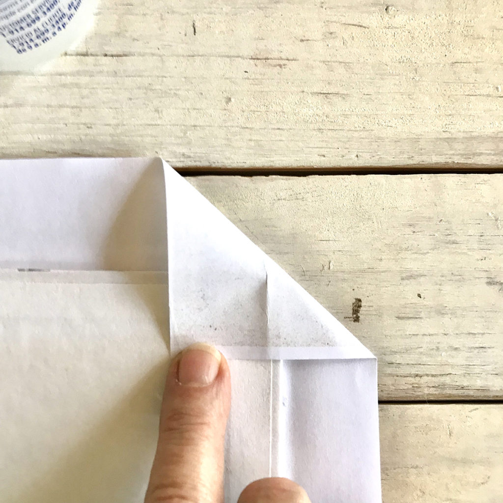 folding edge of paper over book corner