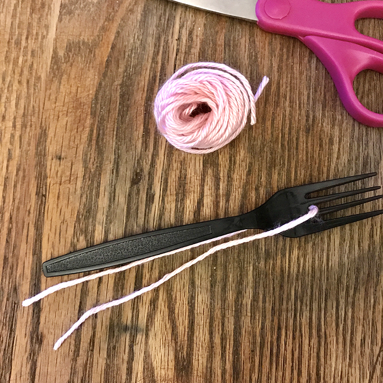 A pair of scissors with yarn and fork
