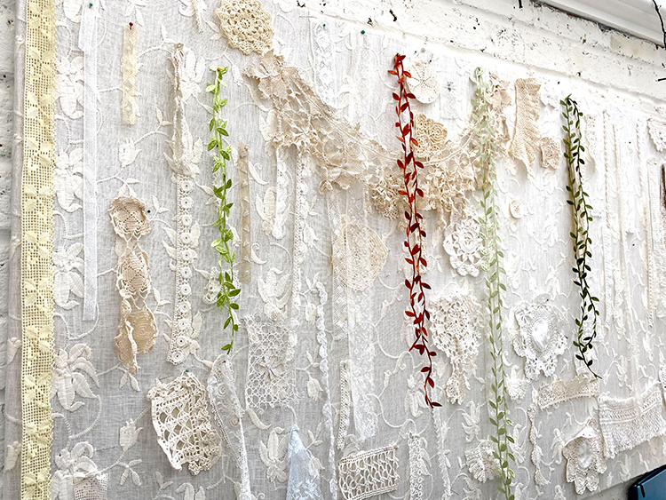 Lace and trims stored on an old window frame – Awesome Craft Room Storage Ideas on a Budget