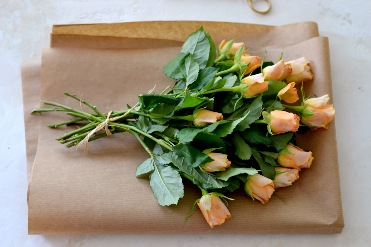 Hands of Caucasian woman wrapping bouquet in brown paper Stock