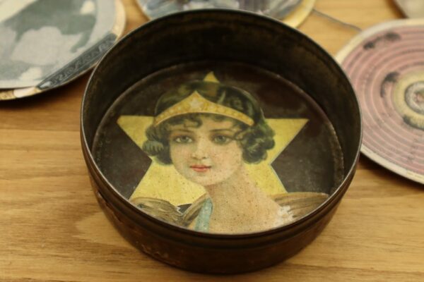 Tin with woman face in bottom