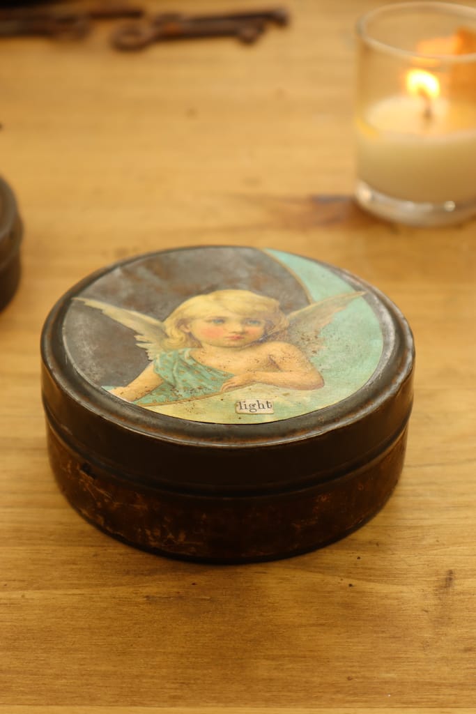 Round tin with angel on lid