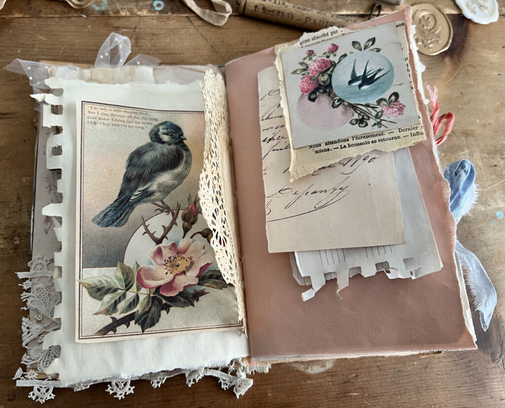 junk journal with gray bird and pink flower on left