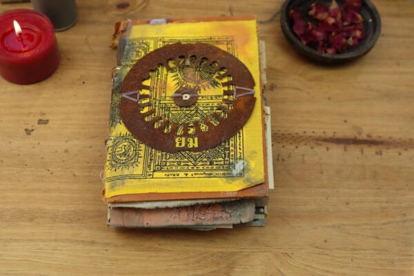 Junk journal cover with yellow print and rusty cog