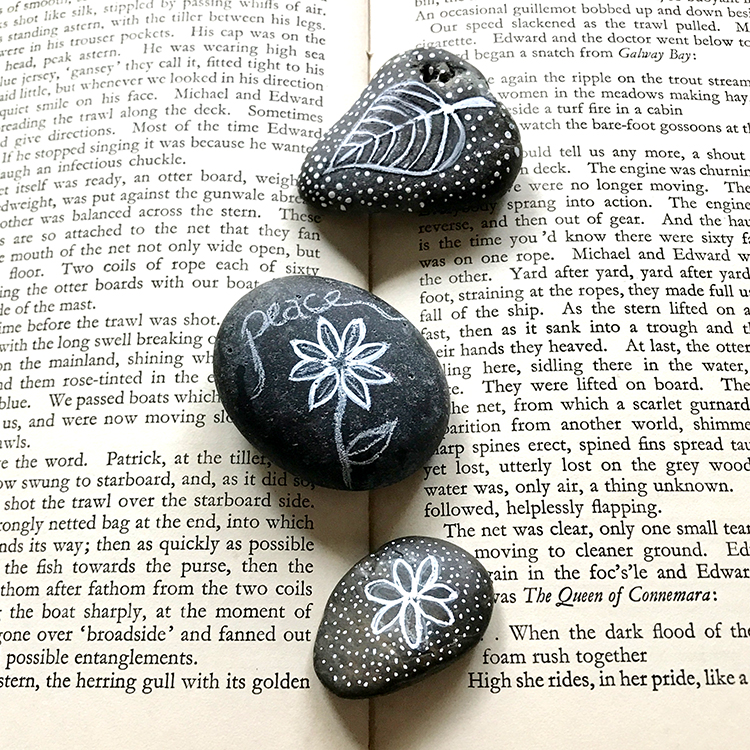 3 black rocks on book pages
