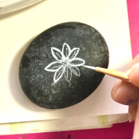 Painting on rock with tiny brush