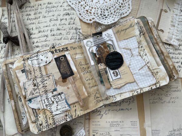 Collaged journal page with black and white ephemera and machine stitching