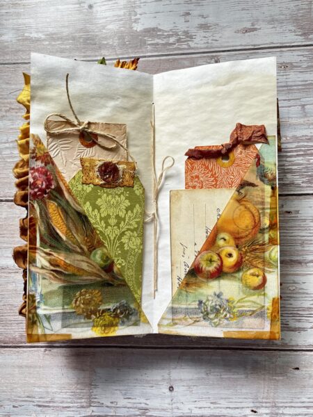 Journal page with pockets and orange, brown and green envelopes