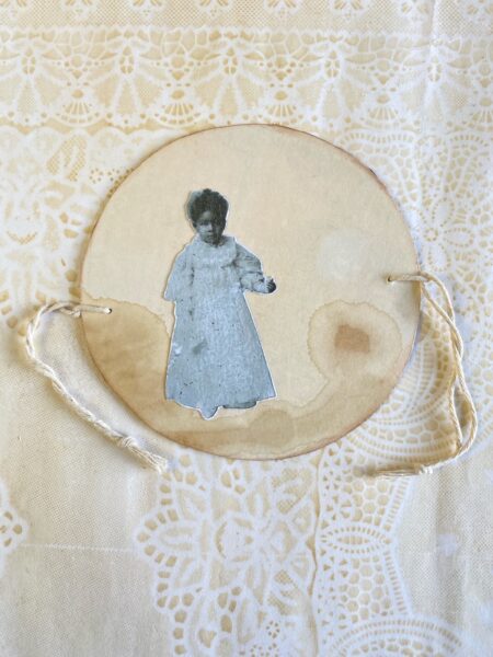 Round card with picture of a child and ribbons attached