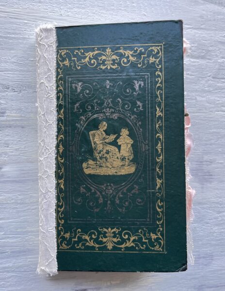 Journal with green cover and gold silhouette of woman and child