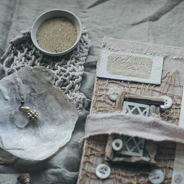 Close up of journal cover showing small window made from pieces of driftwood