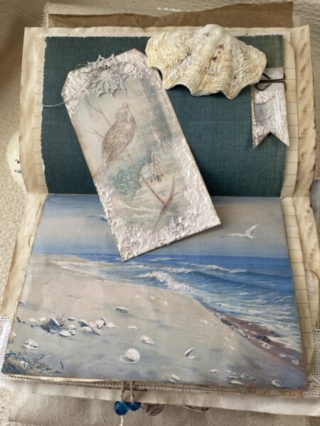 Junk journal spread with seascape image and bird tag