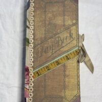 Tall journal cover with tape measure attached to front