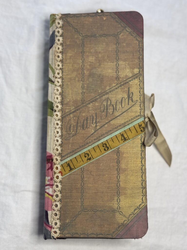 Tall journal cover with tape measure attached to front