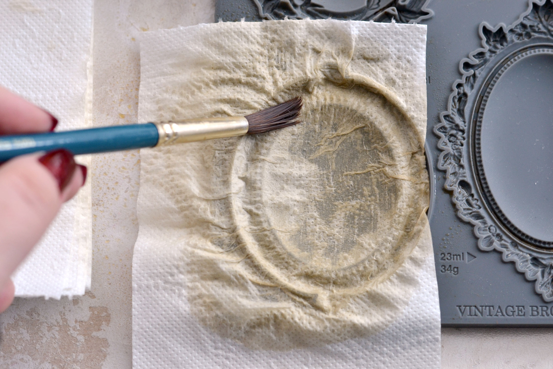 pressing the first layer of toilet paper into the mould