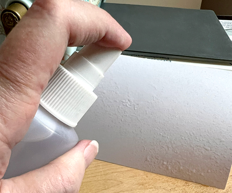 Spritz water onto one side of card