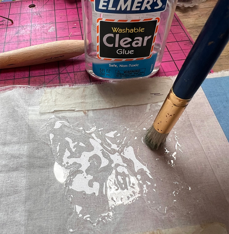 Stencil brush used to move glue into tight spots
