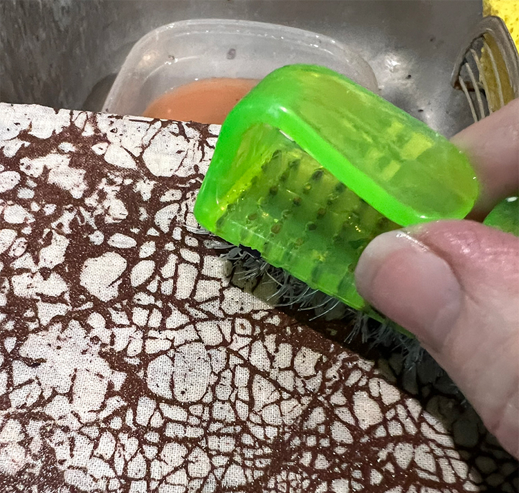 Brush stubborn flour paste off wet cloth with nail brush